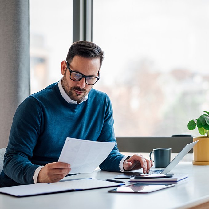 Business owner reviewing documents while planning the sale of a company